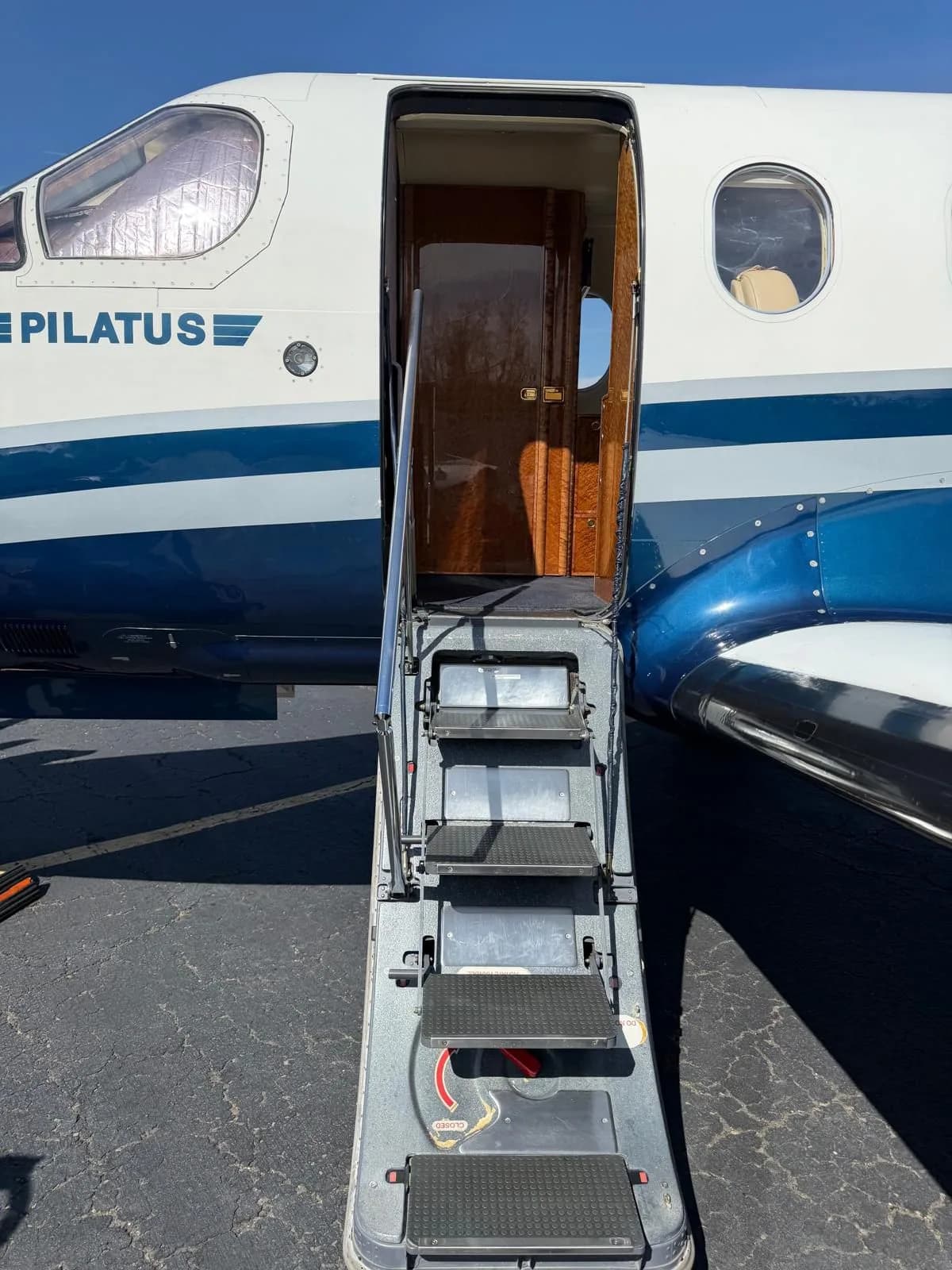 The open passenger door of the Pilatus PC-12 aircraft, showing the integrated airstairs extended.