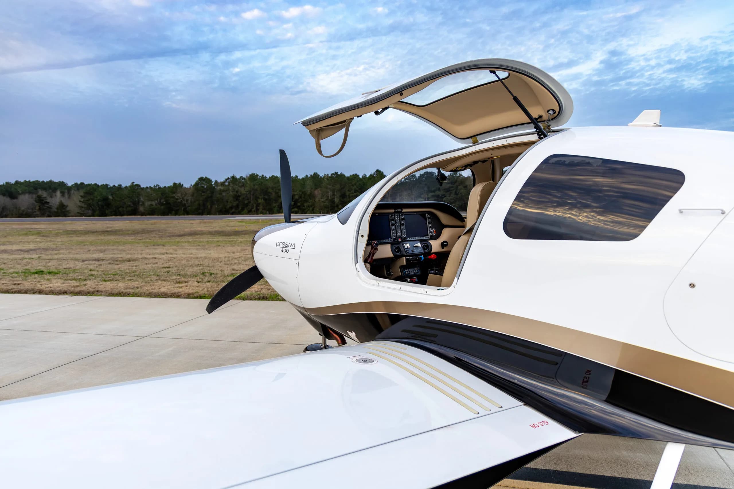 Cessna 400, registration N410TW, parked on the tarmac with the door open, showing the cockpit.