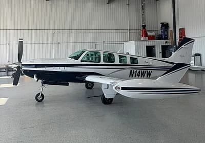 Beechcraft Bonanza in a hangar, side view with tail number N14WW.