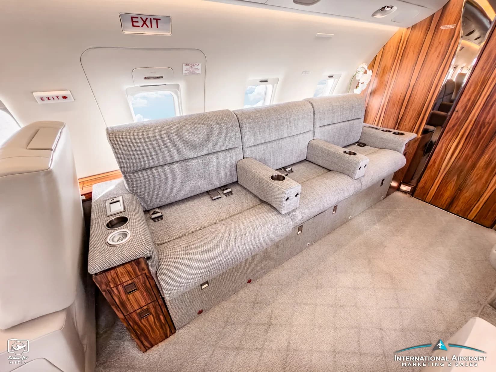 Cabin of the Bombardier Challenger with a gray fabric couch.