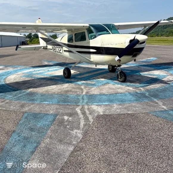 Front-right view of a white and black Cessna 172 N8032T parked on an airfield.
