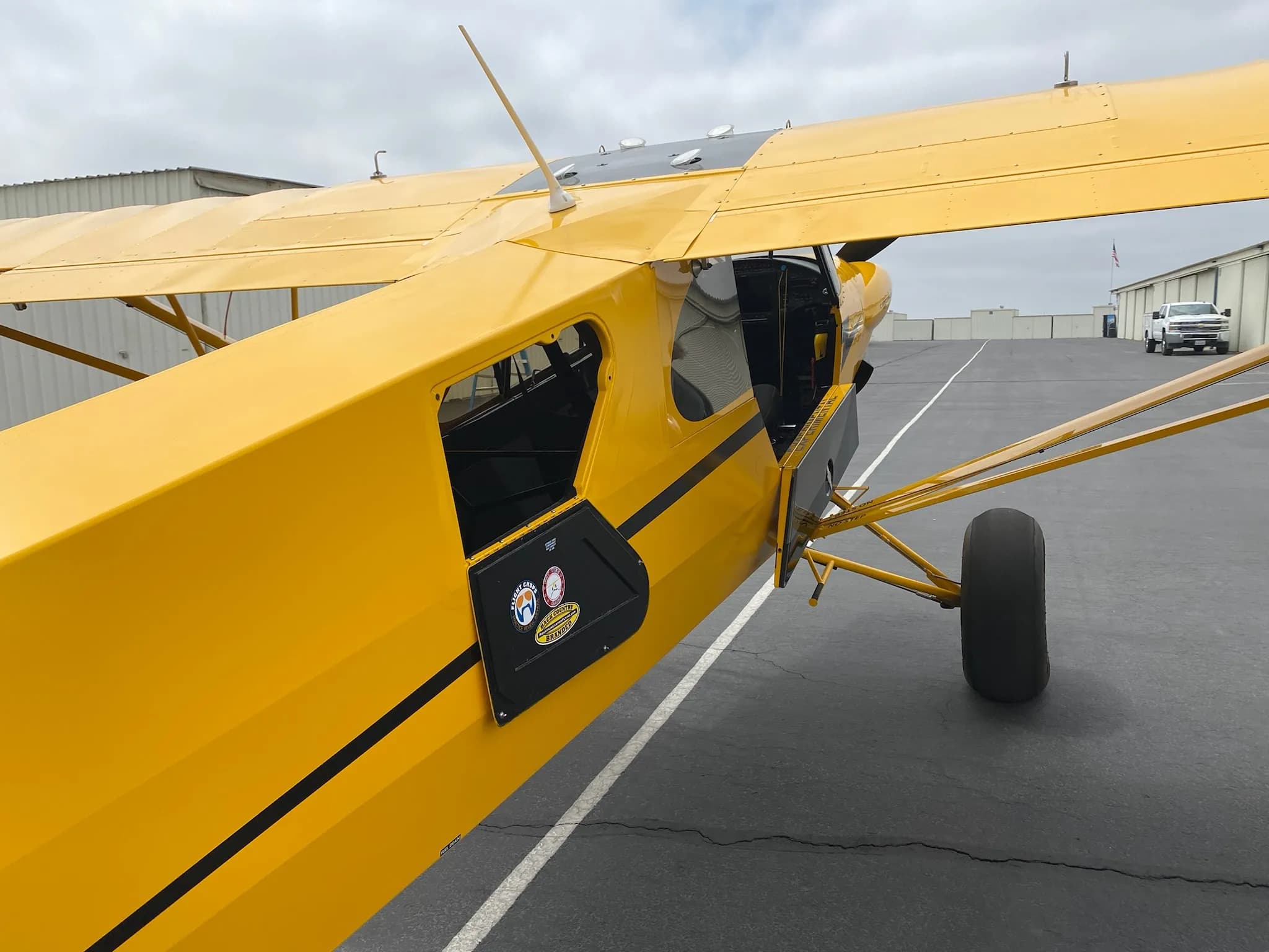Close up of the door and side of a yellow Carbon Cub aircraft.