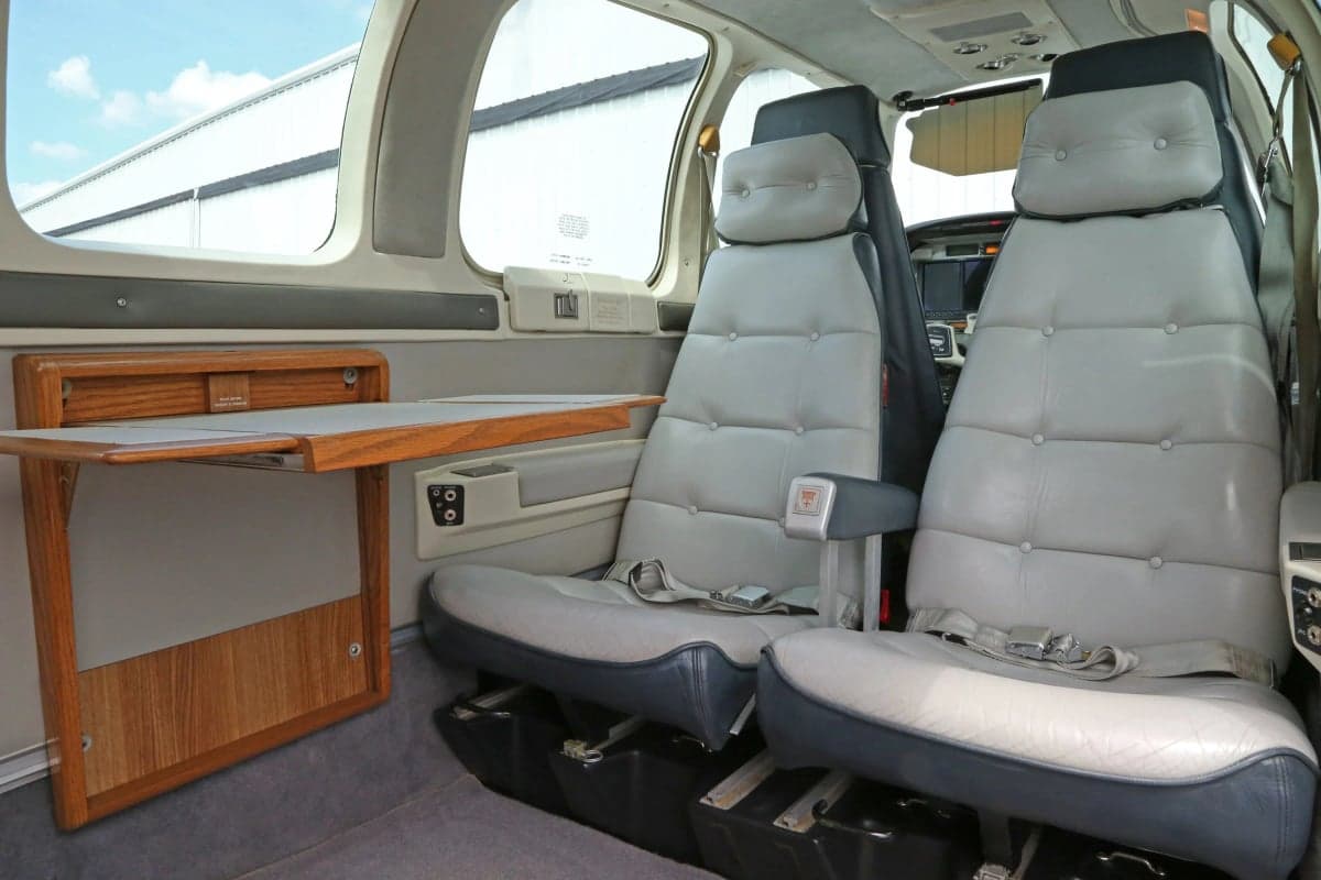 View of the aircraft's cabin with seats and a fold-out table.