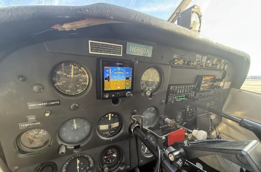 A close-up view of the left side of the Cessna 172 instrument panel, showing flight instruments and a Garmin display.
