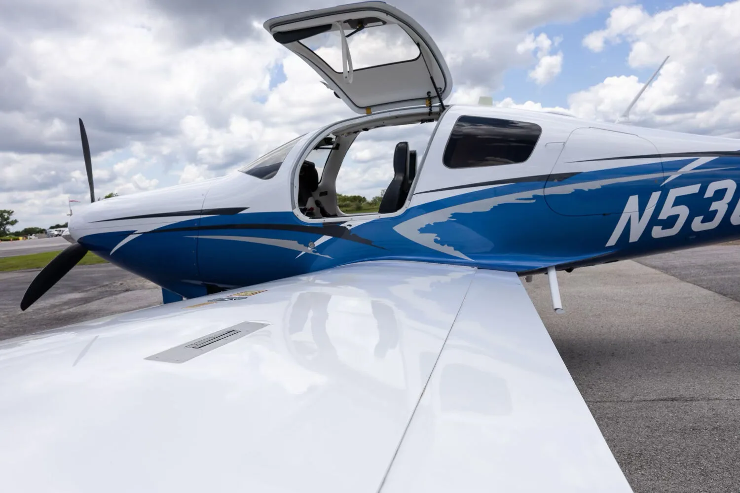 A close-up view of the open gull-wing door and white wing of the Cessna TTX N530JM.