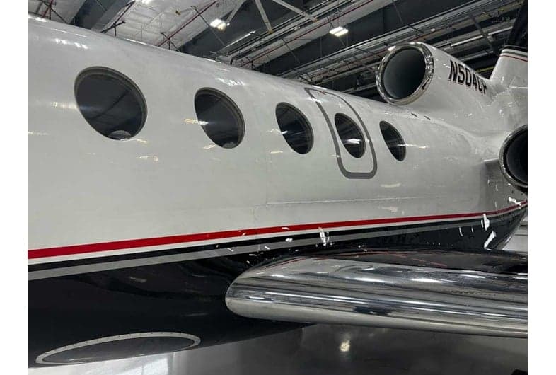 Close up of the side of the N504CP aircraft in a hangar.