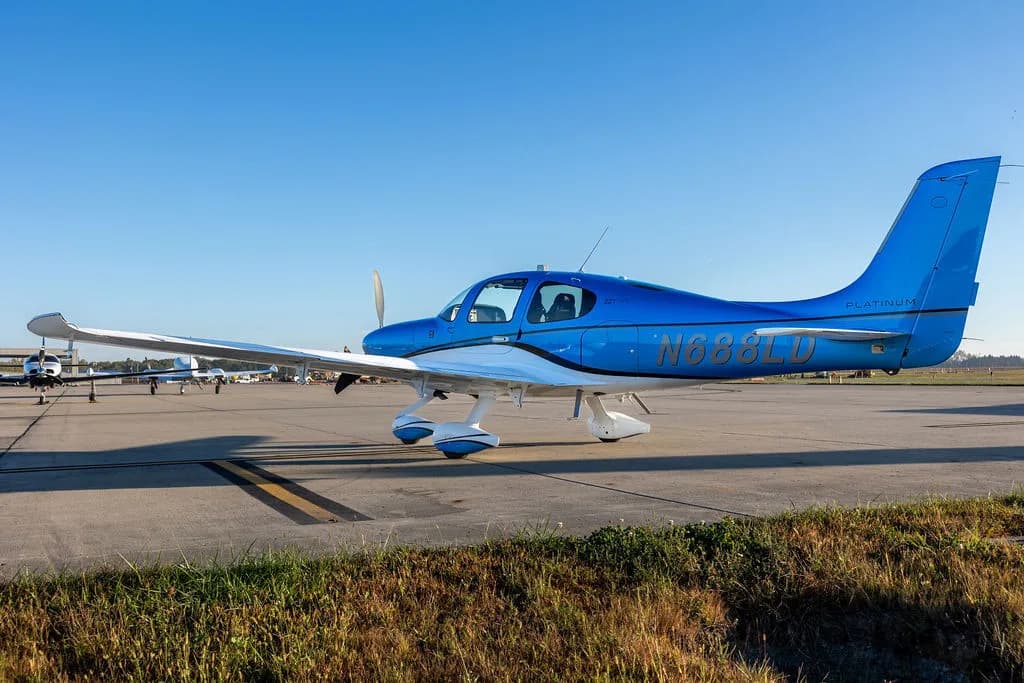 A blue and white Cirrus SR22 aircraft with registration N688LD parked on an airfield.