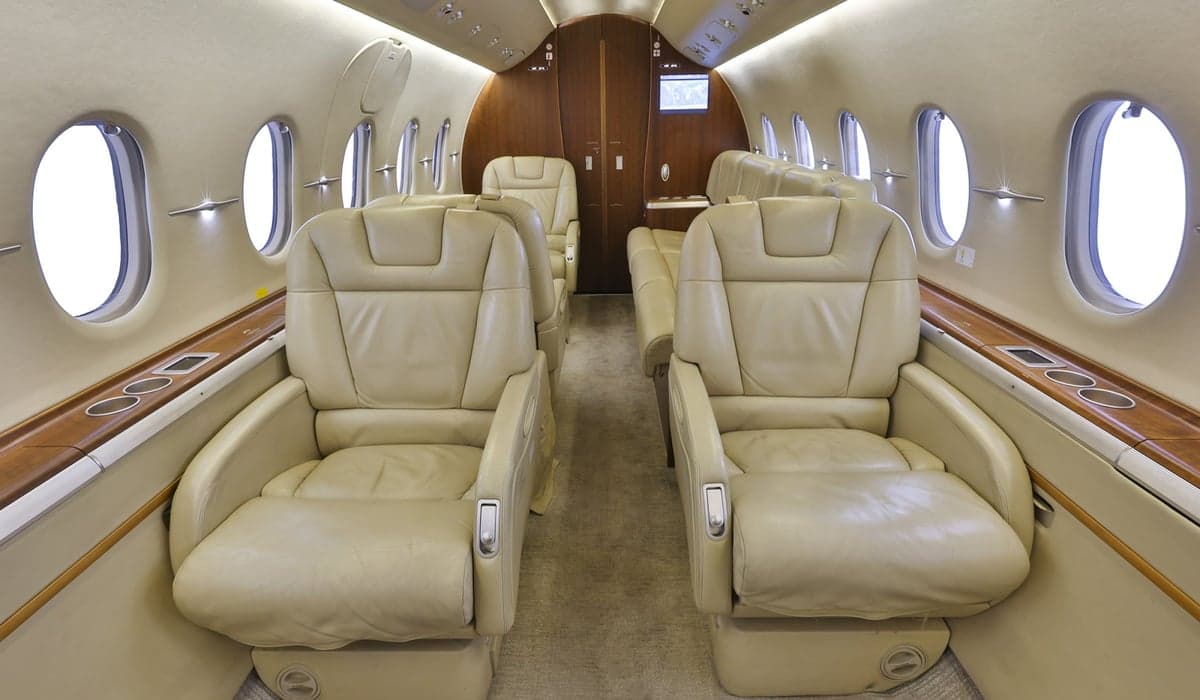 Interior view of the aircraft cabin with beige leather seats.
