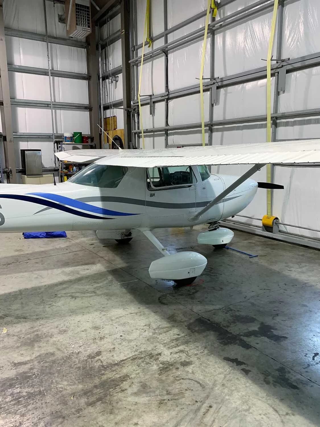 Cessna 172 Skyhawk in a hangar, side view.