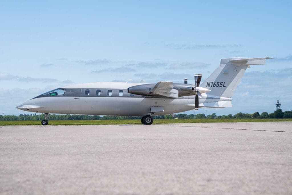 Side view of a Piaggio Avanti EVO aircraft with tail number N165SL on the tarmac.