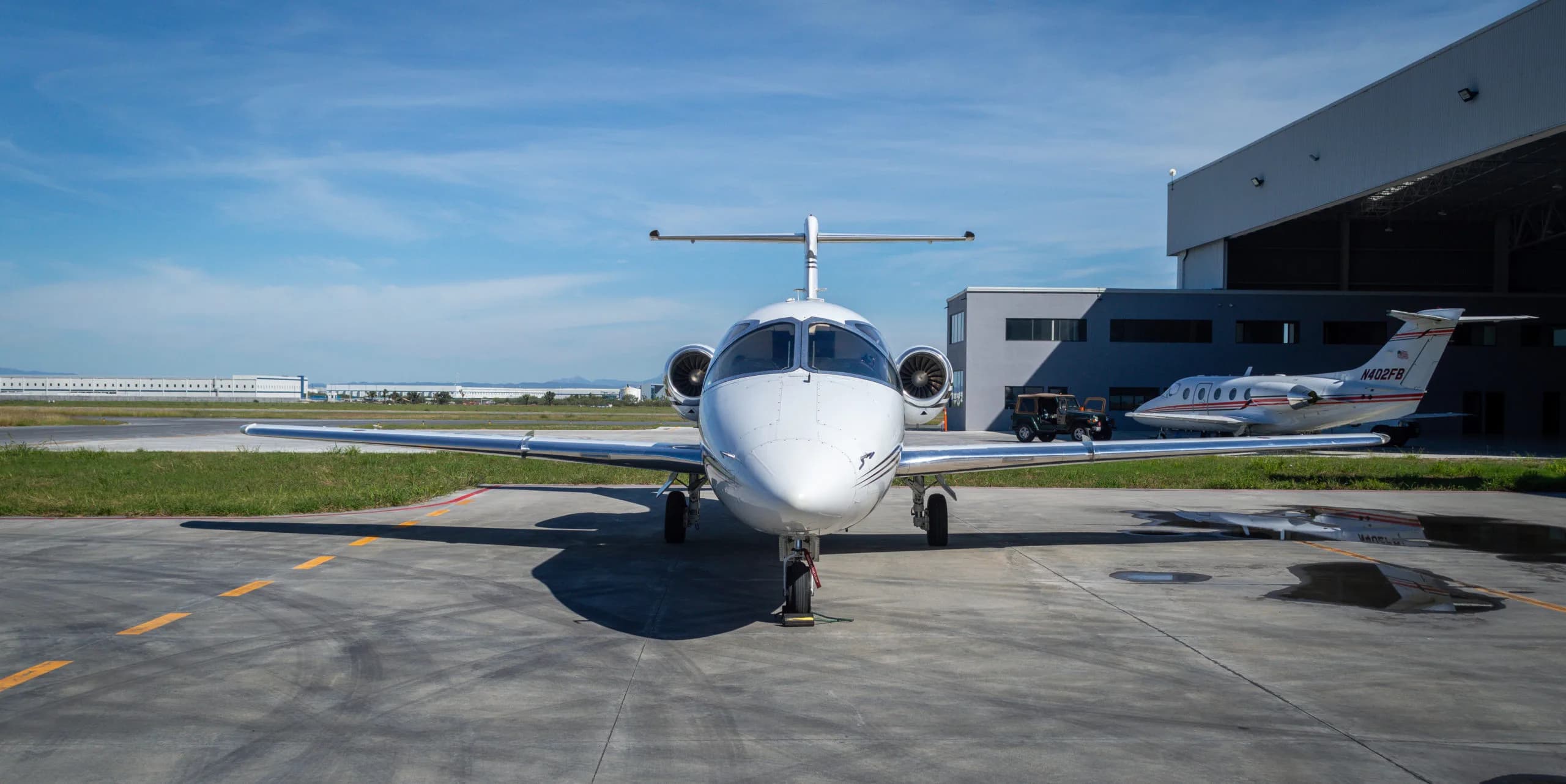 Front view of the Learjet parked on the tarmac with another aircraft in the background.