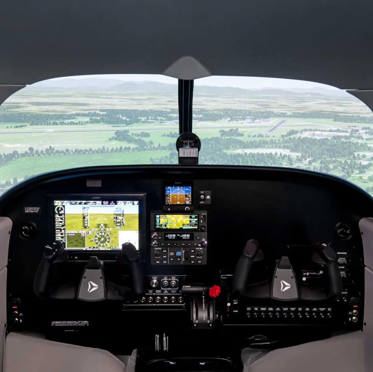 View of the cockpit instrument panel with a view of the landscape outside.