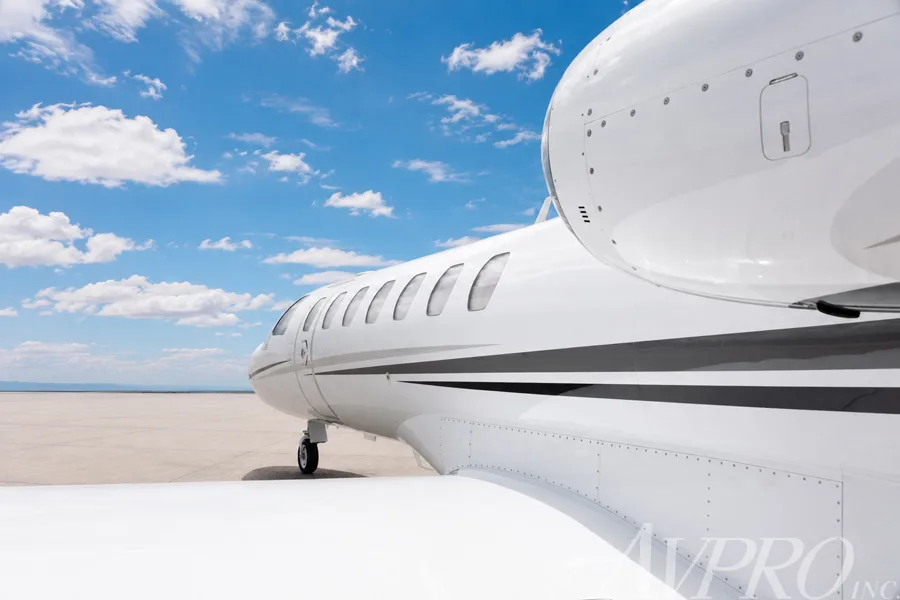 A close-up side view of the white Cessna Citation jet's fuselage, windows, and engine.
