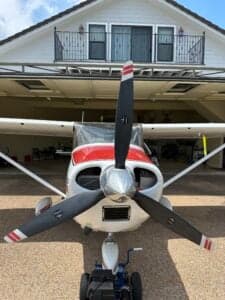 Front view of a Cessna 182 Skylane, registration N71699, with a tow bar attached.