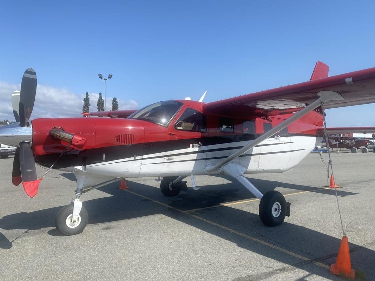 A red and white Quest Kodiak aircraft is parked on the tarmac.