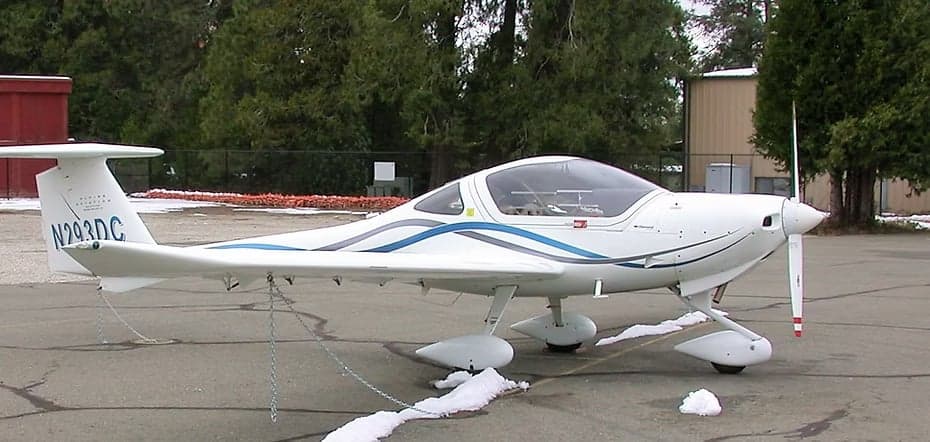 Diamond DA40 aircraft with white and blue paint scheme on the ground.