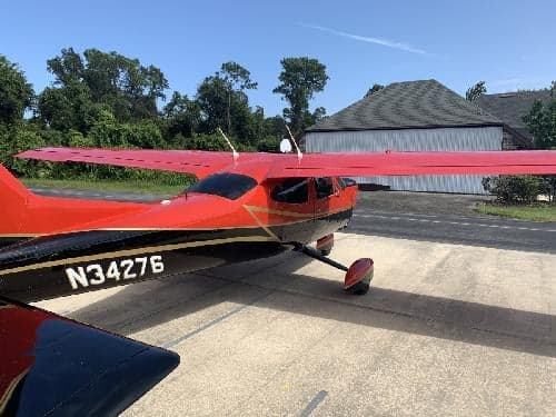 The tail of a Cessna Cardinal RG, registration N34276, is visible in this side view.
