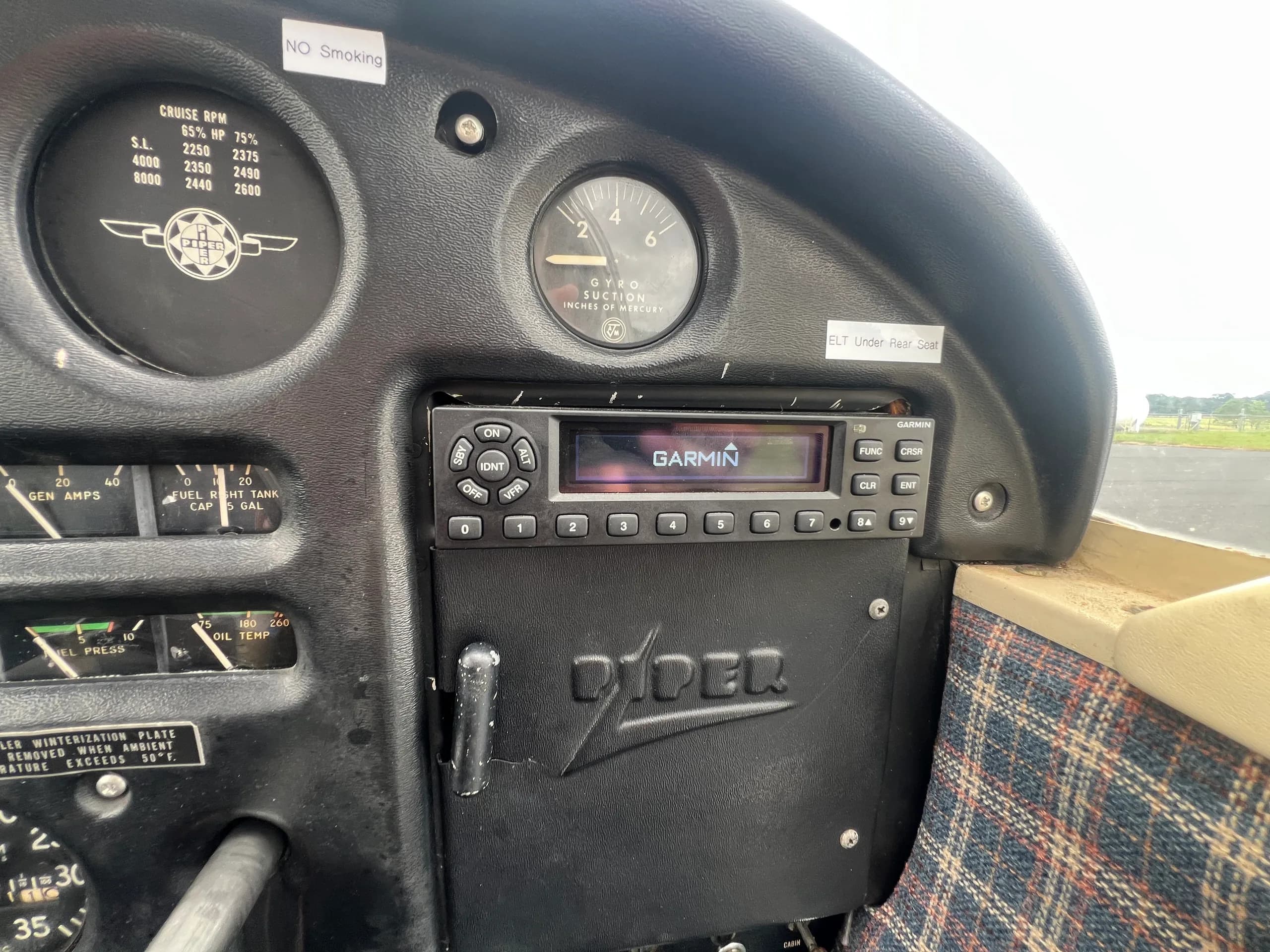 Close-up view of the cockpit instrument panel showing a Garmin radio and other gauges.