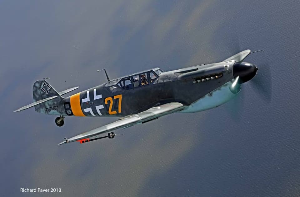 Messerschmitt Bf 109 flying in front of clouds.