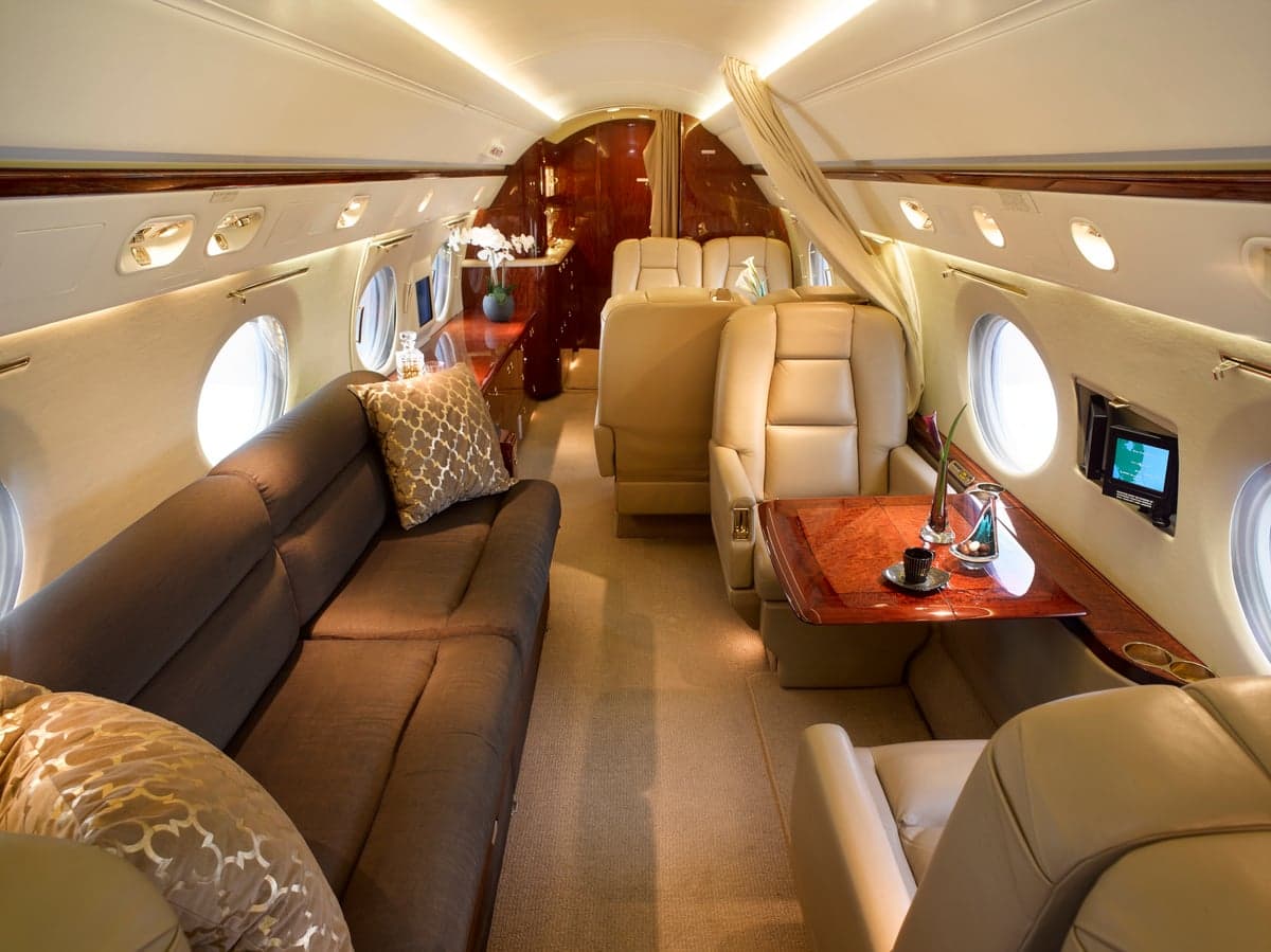 Interior view of the aircraft cabin with a sofa and leather seats.