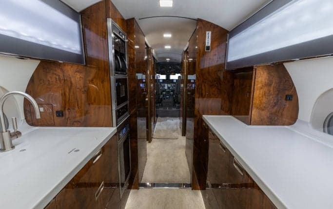 Aircraft cabin interior with a galley and seating area.