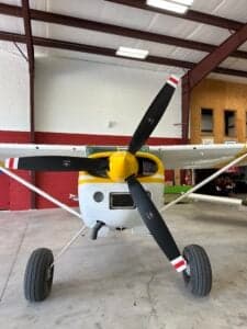 Front view of a Cessna 185 Skywagon with a yellow and white paint scheme.