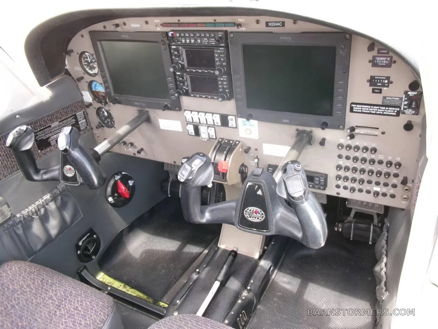 The cockpit of a Piper Archer II (N334AC) featuring a modern glass panel with two large displays and dual yokes.