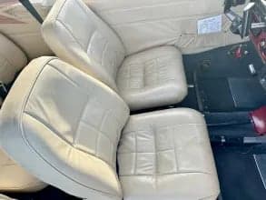 Close-up of the cream-colored leather seats in the interior of a Piper PA-28 Cherokee.