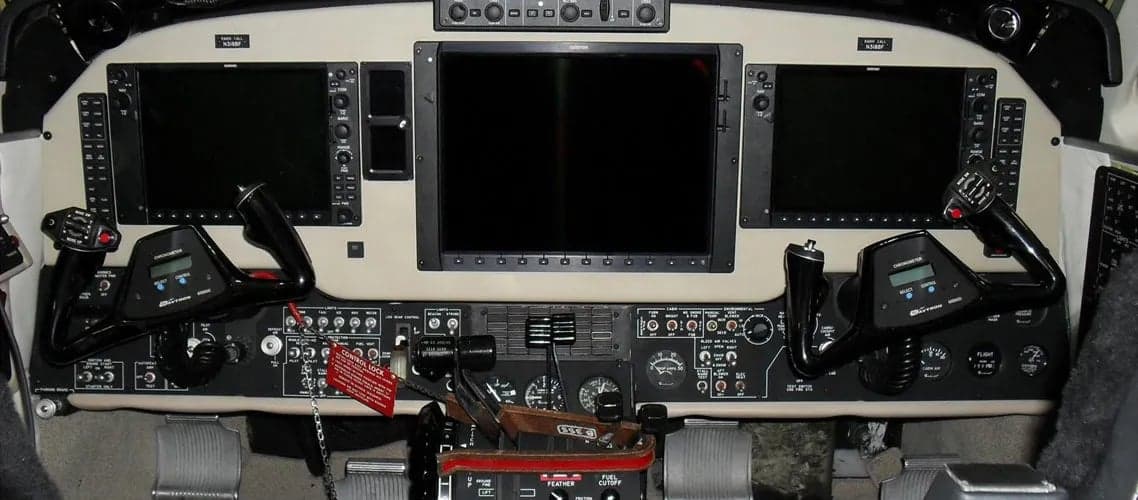 Aircraft cockpit instrument panel with avionics and controls.