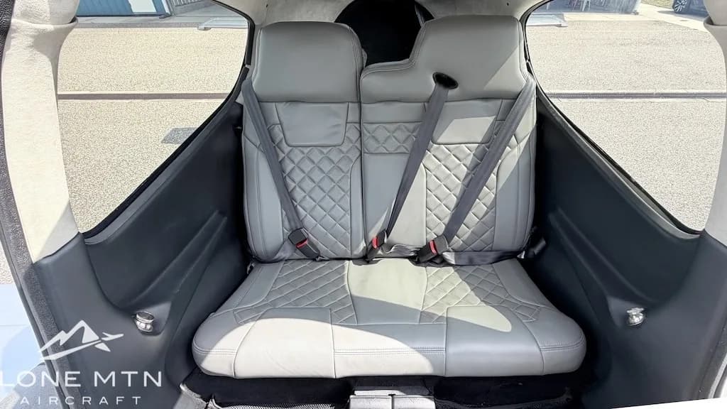 The gray quilted leather rear seats of a Cirrus SR22T aircraft cabin.