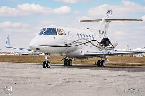 A close-up of a white jet aircraft with registration N97XP parked on the tarmac.