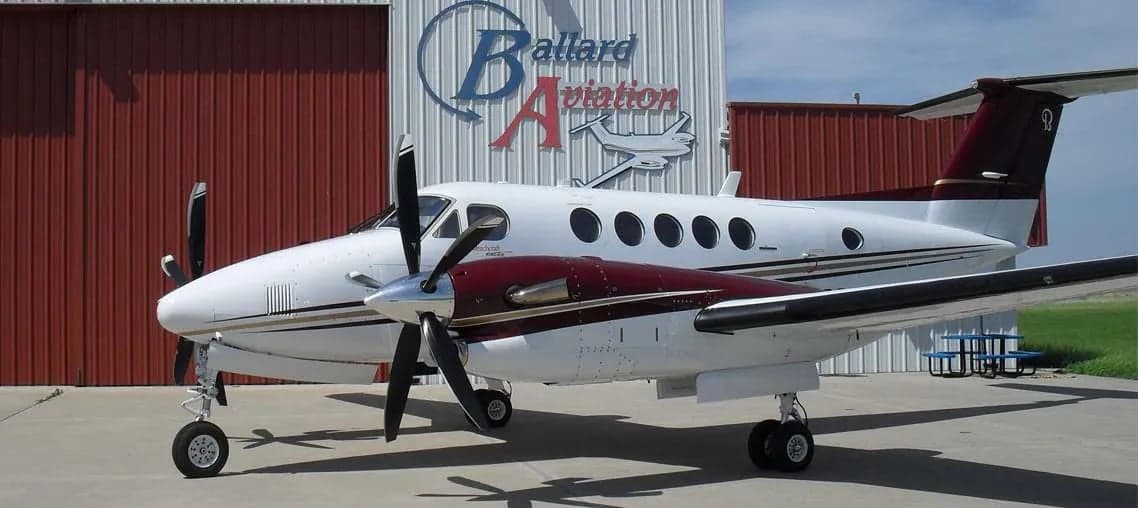A Beechcraft King Air 300 parked in front of a hangar.