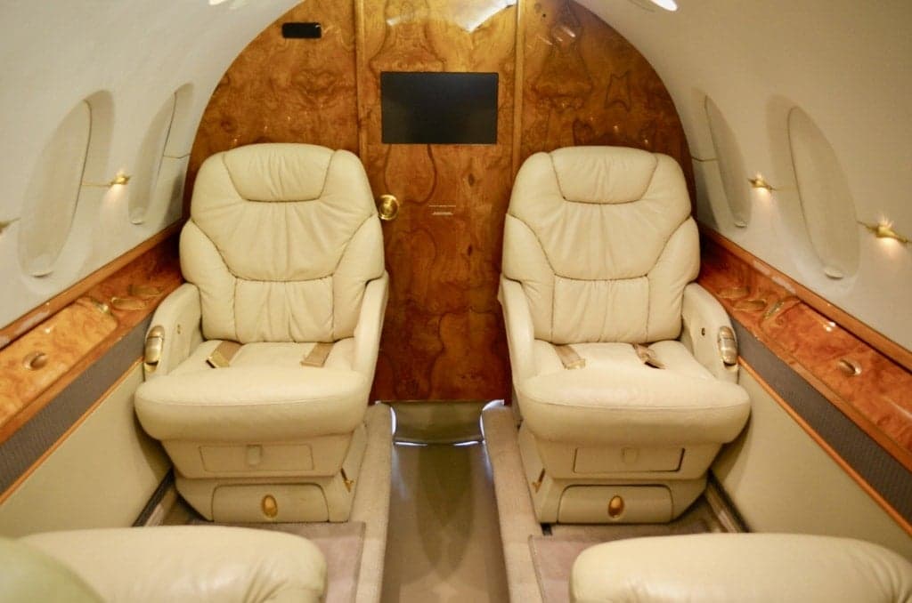 Interior of the aircraft with two leather seats facing each other.