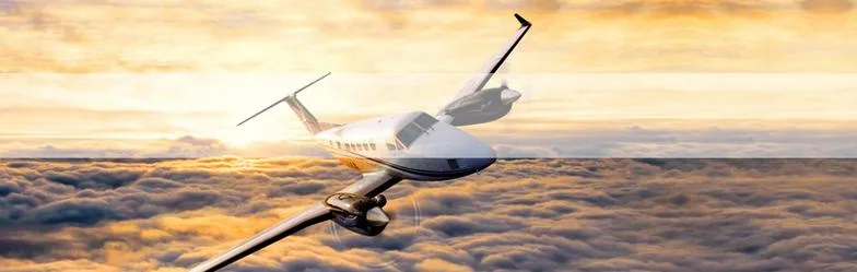 A King Air flying above the clouds at sunset.