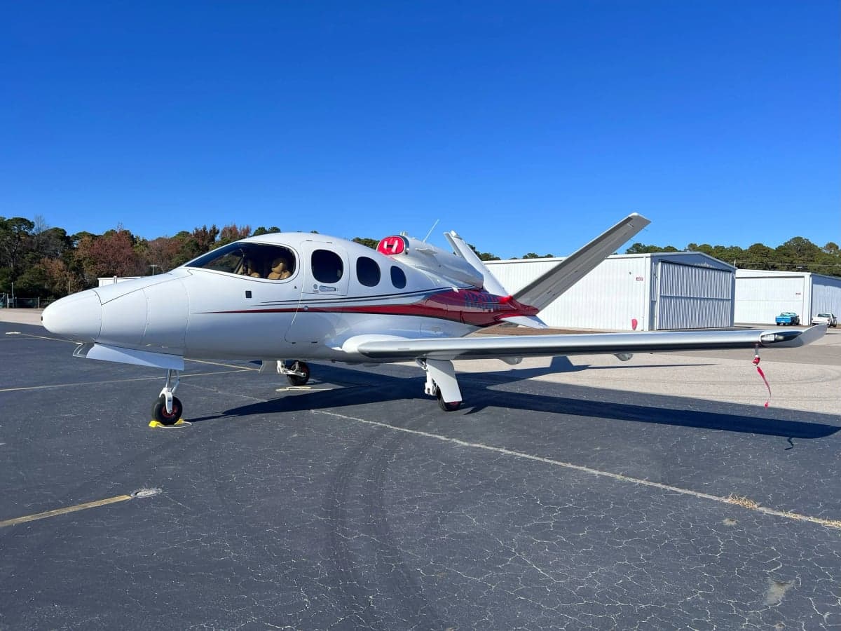 Side view of a white and red aircraft on the tarmac.