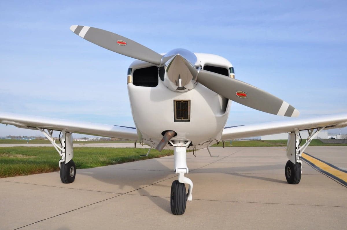 Close up front view of a white and gold aircraft on the tarmac.