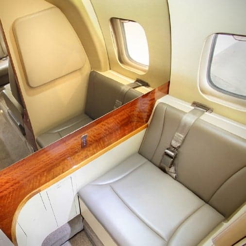 A close-up of the interior of the Piaggio Avanti EVO with leather seats and wood trim.