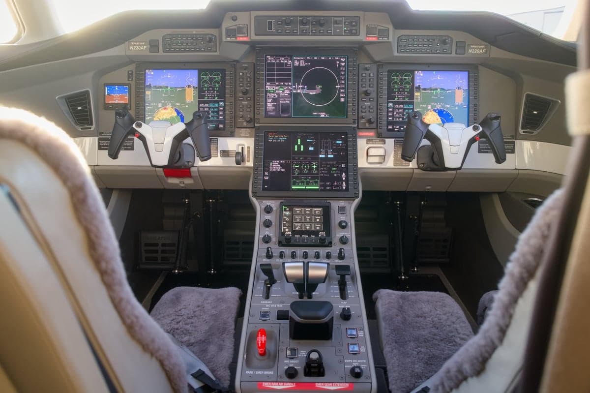 View of the aircraft's cockpit with advanced avionics and sheepskin seat covers.