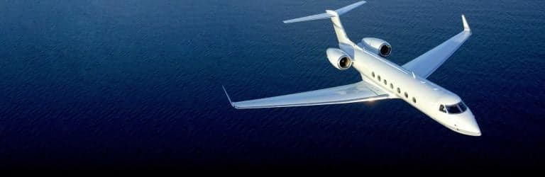 A Gulfstream jet flying over the ocean.