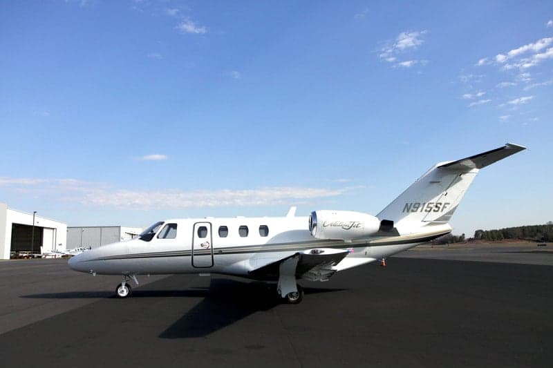 A Citation Jet with tail number N915SF sits on the tarmac in front of a hangar.