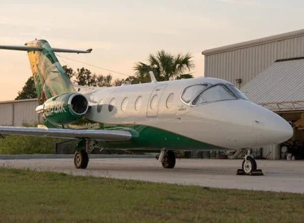 Beechcraft Premier 400A aircraft parked on the ground with a green and white paint scheme.
