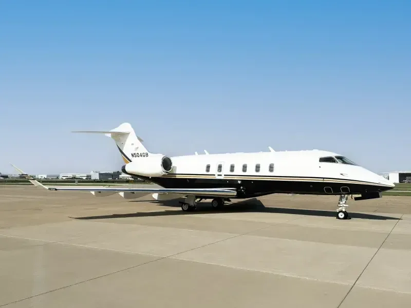 Side view of a Challenger aircraft with a white and black paint scheme on the tarmac.