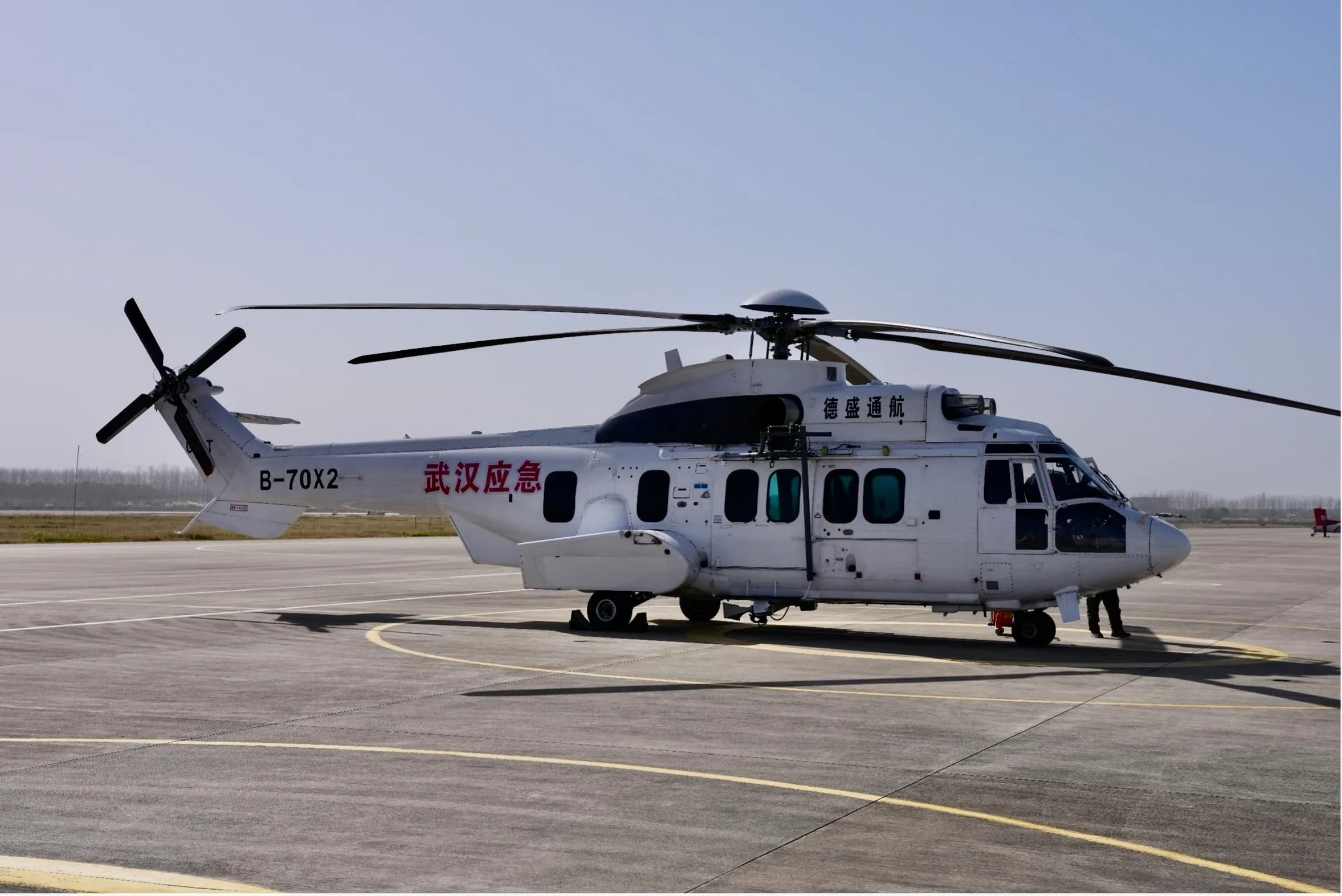 A side view of a white Airbus Helicopters H225 Super Puma on the tarmac.