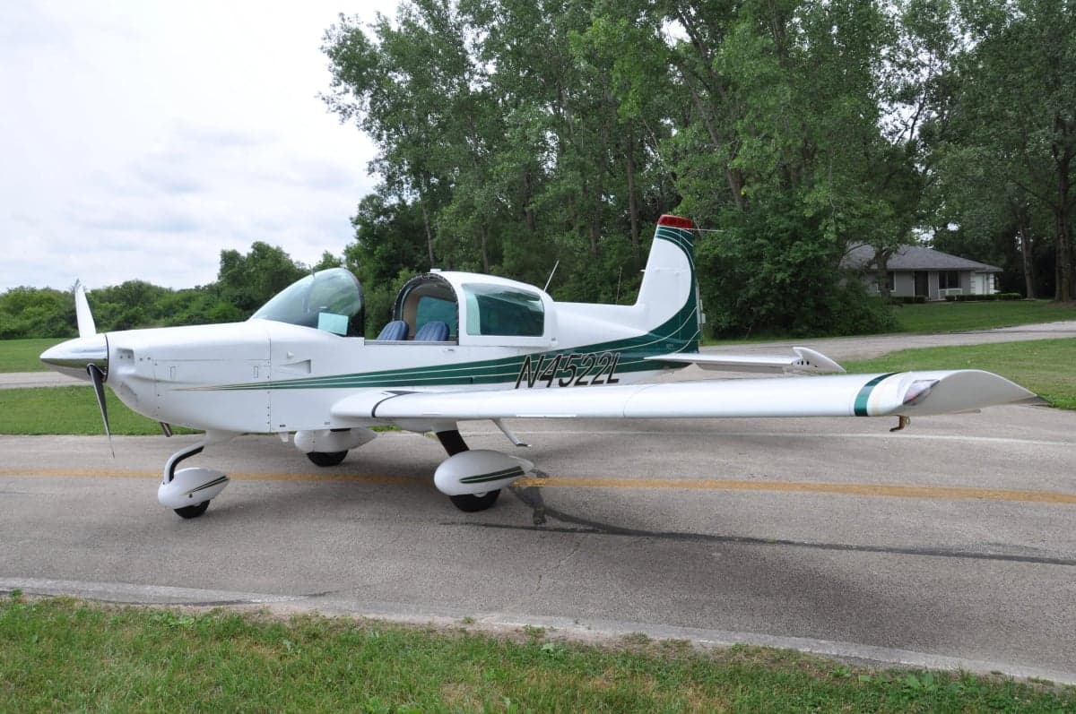 Side view of a white and green aircraft on the tarmac.