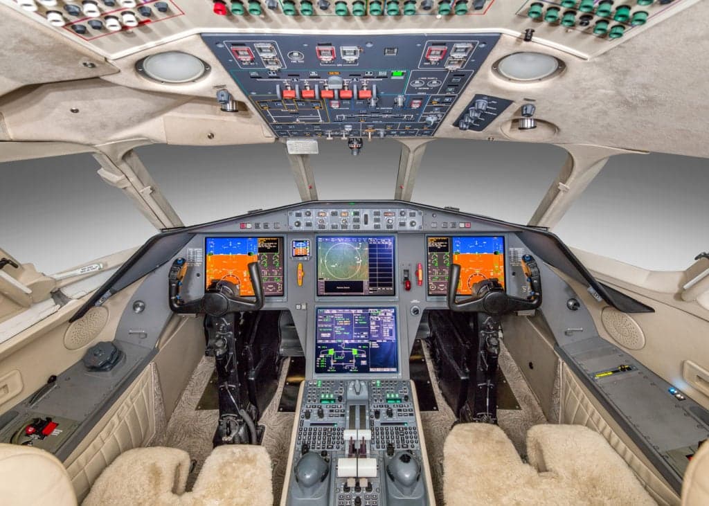 Close up of a leather seat in the aircraft cabin with wood trim.