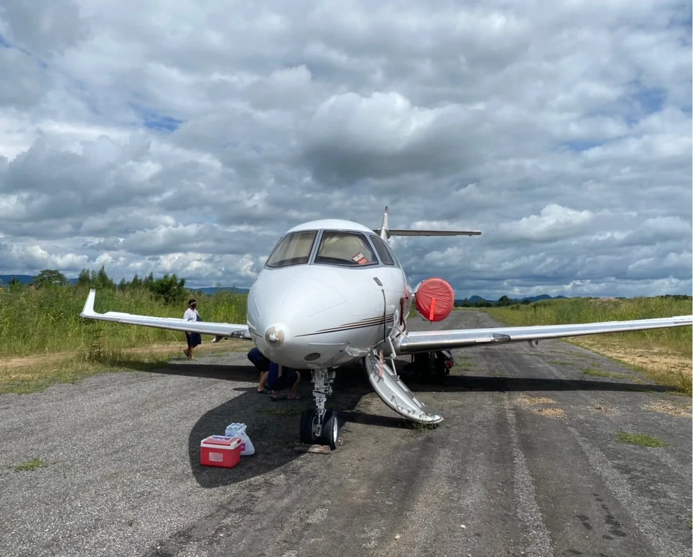 Front view of the aircraft on a runway with the door open.