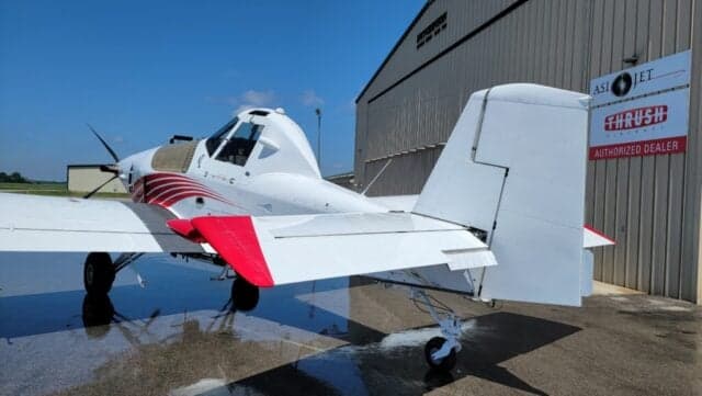 A Thrush 510G aircraft with a white and red paint scheme is parked on the tarmac.