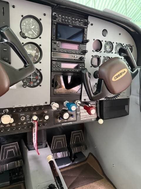 An angled view of the Cessna cockpit instrument panel with yokes and various controls.