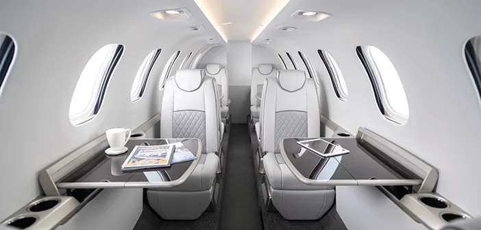 Interior view of the aircraft cabin with seats and tables.