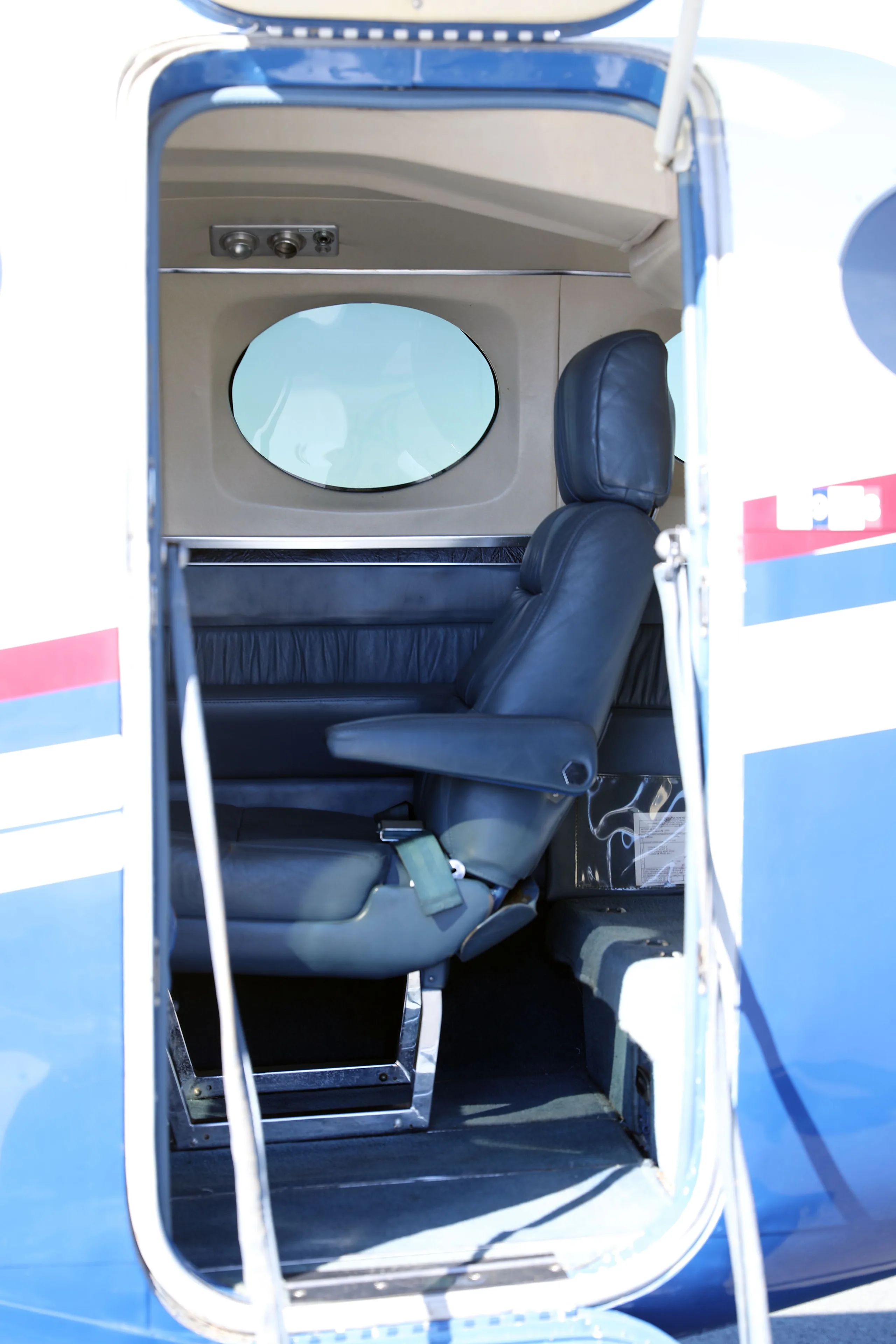 A view into the Cessna 340 cabin through the open door, showing a dark blue leather passenger seat.